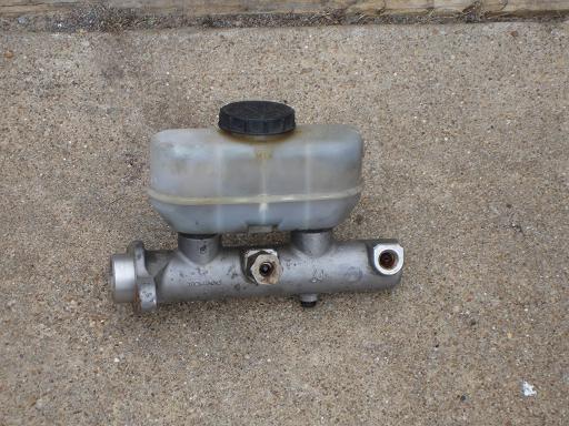 Master cylinder with black cap on concrete