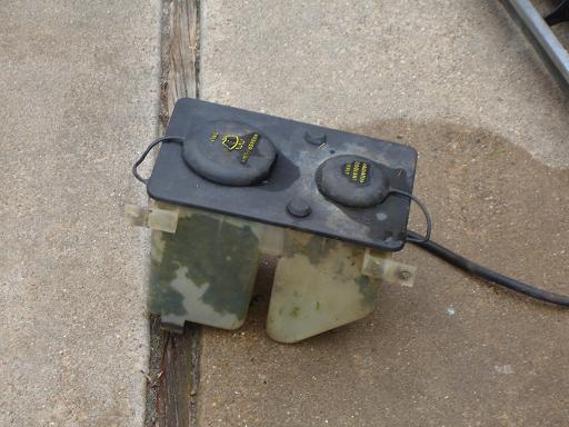 windshield washer fluid reservoir with two caps, one labeled 'washer fluid' and the other 'coolant'