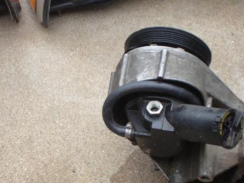 1996 Ford F-150 - Power steering pump with pulley and hose, part of a vehicle's steering system.