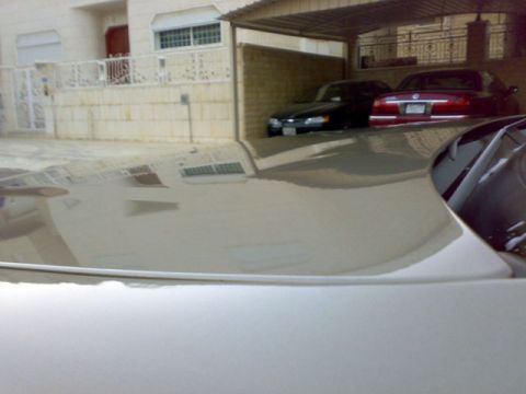 2007 Mercury Grand Marquis - Reflection of a building and two cars is visible on the hood of a car.