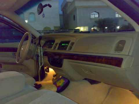 2007 Mercury Grand Marquis - The interior of a 2007 Mercury Grand Marquis features a wood-grain trim on the dashboard and a beige interior.