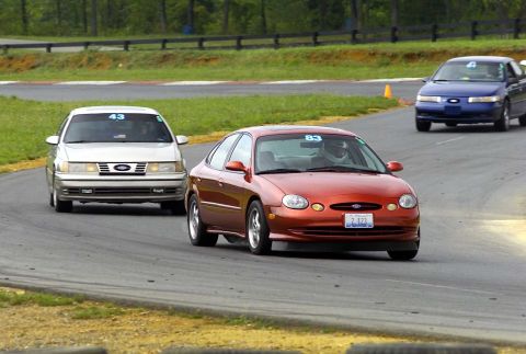 1997 Ford Taurus - Orange 1996 Ford Taurus with number 83 on the windshield navigates a turn on the race track.