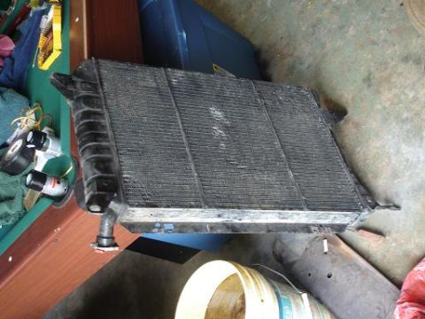 1996 Ford F-150 - A vehicle radiator is shown removed from its original location, resting on a floor.