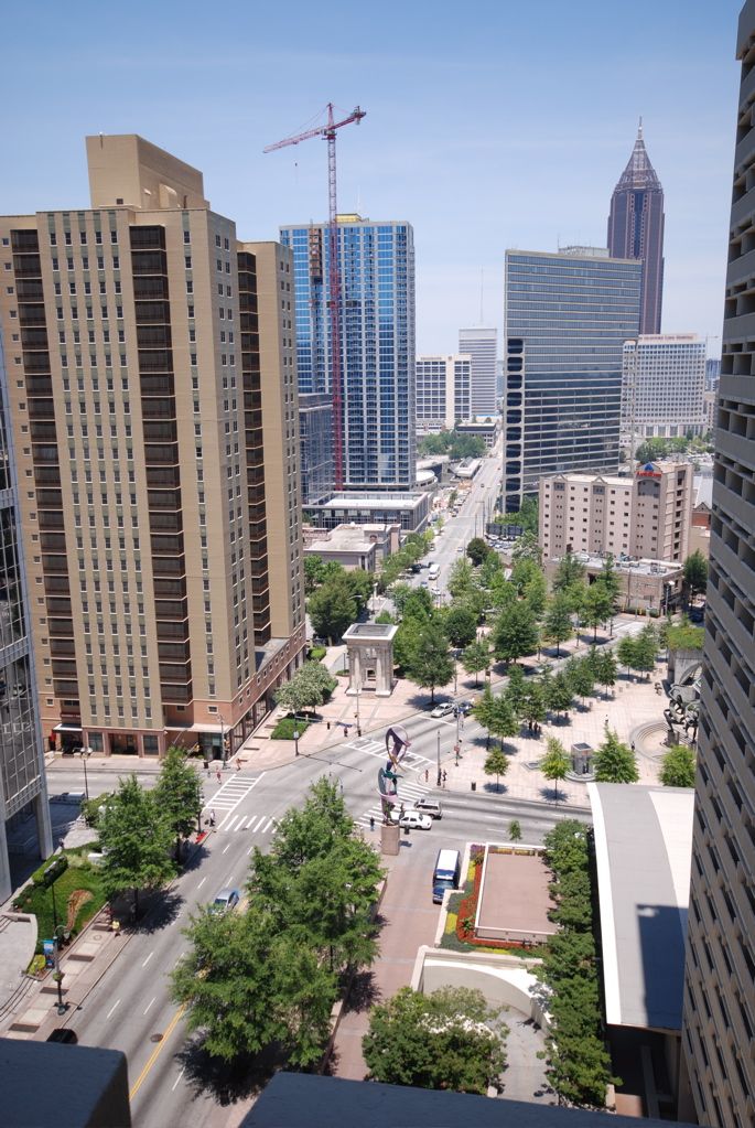 Cityscape view with tall buildings, trees, and a street below