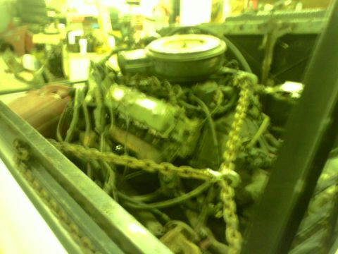 1982 Ford Bronco - The engine bay is cluttered with hoses and chains, obscuring details of the vehicle.