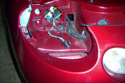 1997 Ford Taurus - Close-up of the headlight housing area on a 1997 Ford Taurus, showing exposed wiring.