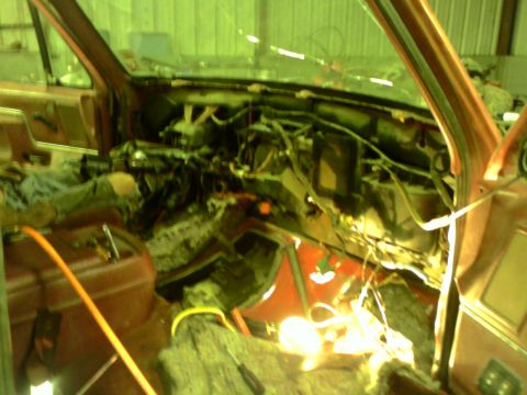 1982 Ford Bronco - The interior of a vehicle is shown with the dashboard disassembled, revealing wiring and various components.