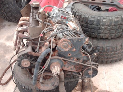 1982 Ford Bronco - This is a V8 engine assembly, likely removed from a vehicle, with various components visible including the carburetor and exhaust system.