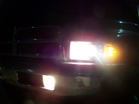 2001 Dodge 1500 - Front view of a 2001 Dodge 1500 showing the grille and illuminated headlights.