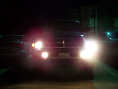 2001 Dodge 1500 - A Dodge Ram pickup truck is parked at night, its headlights illuminating the scene.