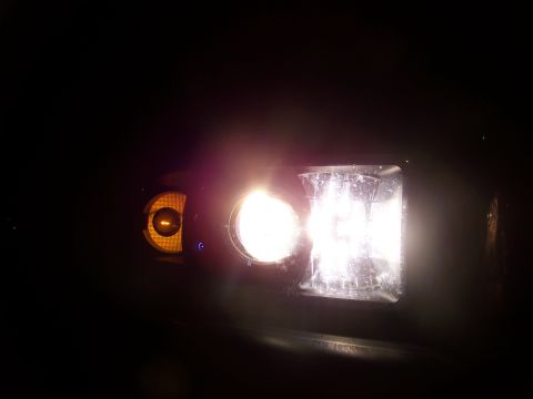 2001 Dodge 1500 - Headlight assembly illuminated at night, showing the main bulb and amber turn signal.