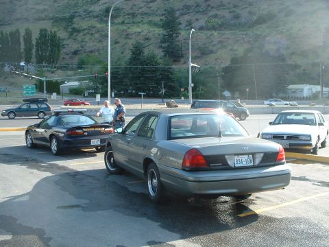 2000 Ford Crown Victoria - A 2000 Ford Crown Victoria police car is parked next to other vehicles.