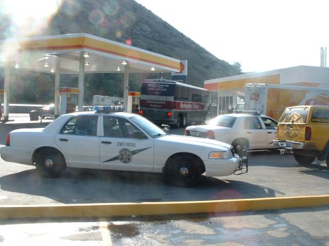 2000 Ford Crown Victoria - A white State Patrol car is parked at a gas station with other vehicles present.