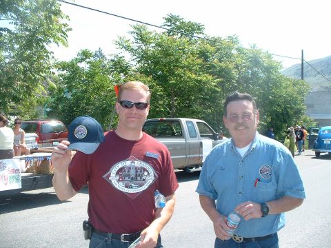 2000 Ford Crown Victoria - Two men pose for a photo at a parade, with several vehicles visible in the background.