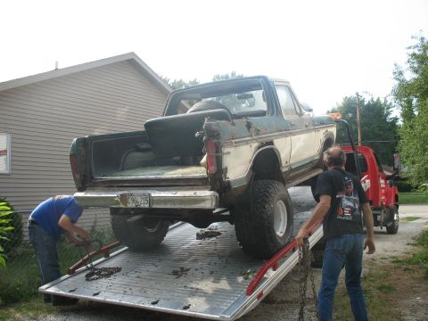1978 Ford Bronco - A 1978 Ford Bronco is loaded onto a tow truck, showing its rear end and the two-tone paint scheme.