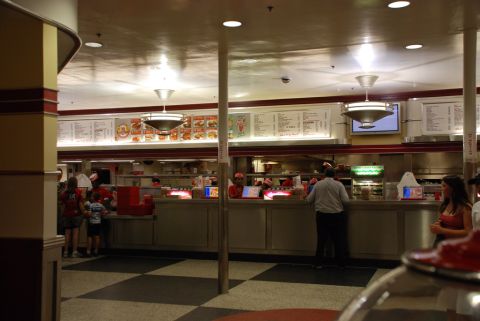 1996 Ford Bronco - People are ordering food at a diner counter with menus displayed on the wall.