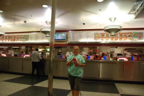 1996 Ford Bronco - A woman stands in a fast food restaurant with menu boards displayed above the counter.