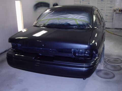 1996 Ford Crown Victoria - Car in paint booth, likely undergoing refinishing. Front end is taped off.