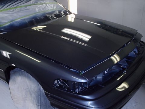 1996 Ford Crown Victoria - A car is being prepped for painting, with protective plastic covering parts of the bodywork.