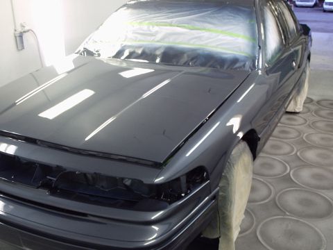 1996 Ford Crown Victoria - A dark gray 1996 Ford Crown Victoria is seen in a paint booth, with its front end masked for refinishing.