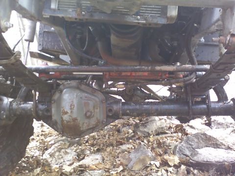1991 Ford Bronco - The undercarriage of a vehicle, with visible suspension and engine parts, is shown in this close-up photograph.