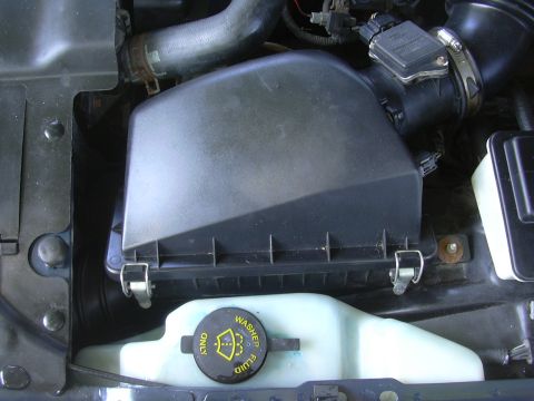 1996 Ford Crown Victoria - Close-up view of the engine bay, showing the air filter housing and washer fluid reservoir.