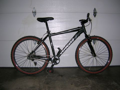 1997 Ford Probe - A black Specialized Hardrock mountain bike is shown in a side profile against a garage door.
