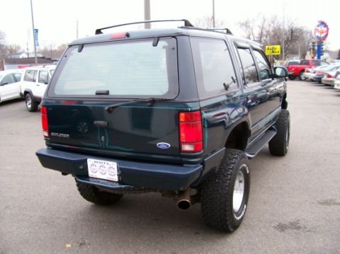 1994 Ford Explorer - Rear view of a 1994 Ford Explorer with a lifted suspension and off-road tires parked in a lot.