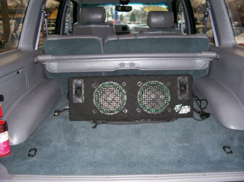 1994 Ford Explorer - The cargo area of a 1994 Ford Explorer features a dual subwoofer enclosure and a cargo cover.
