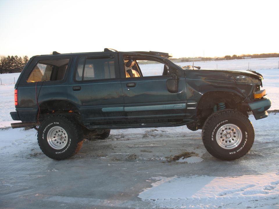 Side view of a lifted 1994 Ford Explorer with large tires on ice