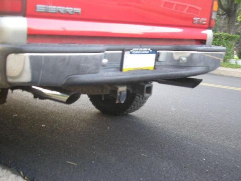 1994 Ford Probe - Rear view of a red GMC Sierra pickup truck, showing the bumper, exhaust, and trailer hitch.