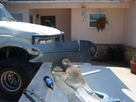 1995 Ford Bronco - Custom metal part held in front of a white truck, possibly for modification.