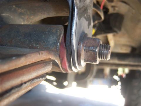 1995 Ford Bronco - Leaf spring assembly with bolt and nut, showing a red bushing.