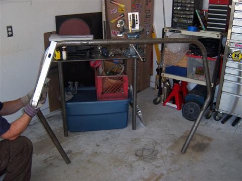 1995 Ford Bronco - A metal rollcage is shown in a garage, with tools and storage shelves in the background.