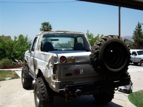 1995 Ford Bronco - Rear view of a white 1995 Ford Bronco, showing its spare tire and aftermarket bumper.