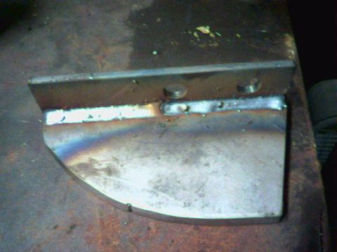 1991 Ford Bronco - A metal part with visible weld marks and two circular holes is shown.