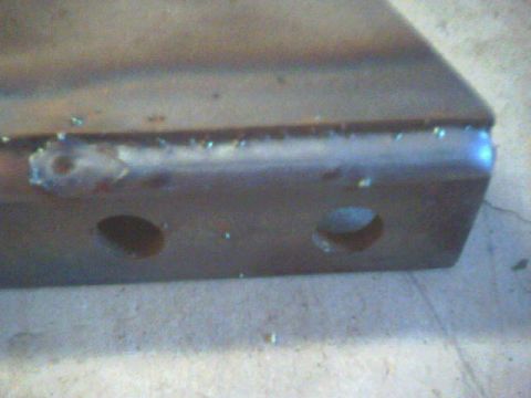 1991 Ford Bronco - This metal part has two holes and appears to be a component from a larger assembly.