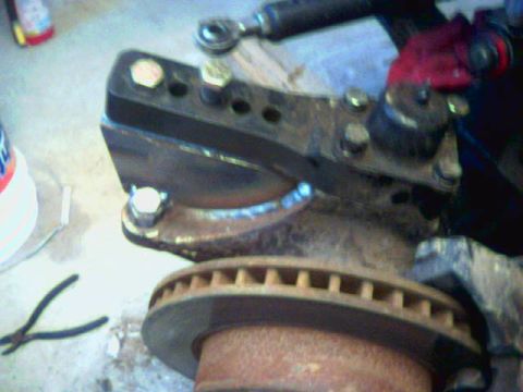 1991 Ford Bronco - A close-up view of a vehicle's suspension components and a brake rotor, possibly undergoing maintenance or repair.