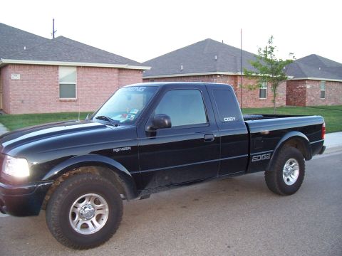 2003 Ford Ranger - This black Ford Ranger pickup truck is parked on a residential street.