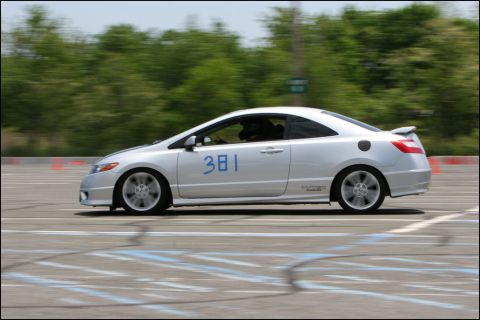 2001 Mercury Grand Marquis - A silver coupe with racing numbers drives on a track during an event.