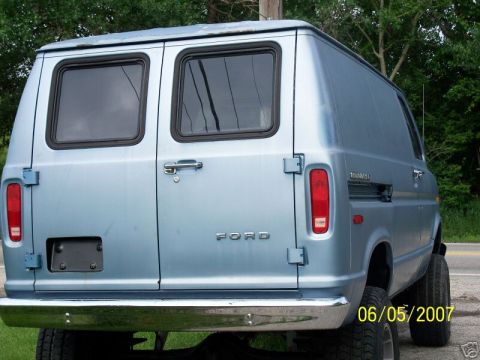 1978 Ford E250 - Rear view of a light blue Ford Econoline van showing the windowed barn doors with chrome handle, 'FORD' lettering across the lower door, bl…