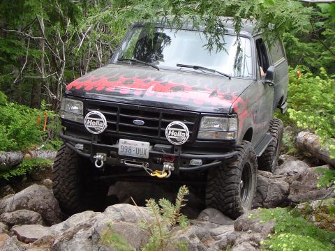 1989 Ford Bronco - This 1989 Ford Bronco tackles a challenging rocky trail, its flame decals adding a custom touch to its off-road adventure.