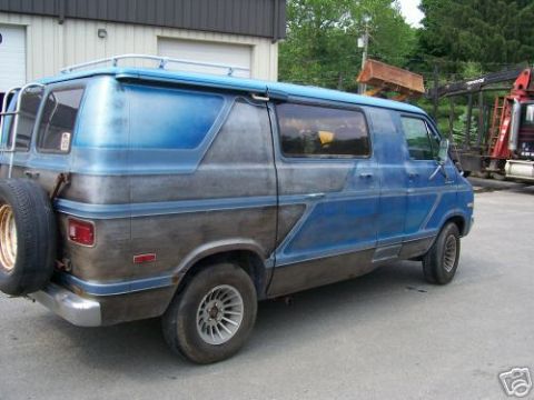 1978 Ford E250 - Rear three-quarter view of a blue van, possibly a 1978 Ford E250, with a spare tire mounted on the back.
