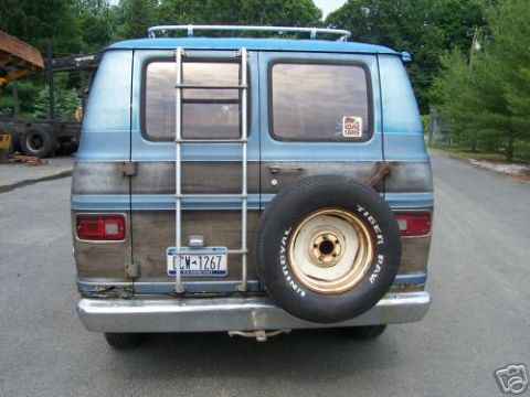 1978 Ford E250 - Rear view of a two-tone custom van with roof ladder and rear-mounted Uniroyal Tiger Paw spare tire, plate CWM-1267.