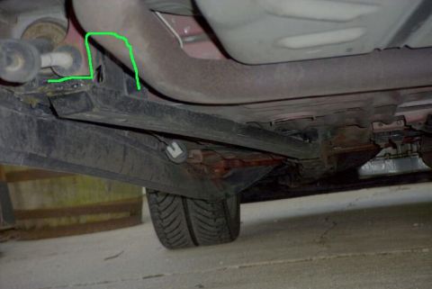 1997 Ford Taurus - Underside view of a vehicle's rear left area showing rusty exhaust piping, black frame rails and a subframe connector, with a green outline…
