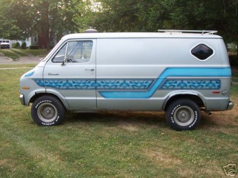 1978 Ford E250 - This van has custom blue flame graphics along its side and a diamond-shaped rear window.