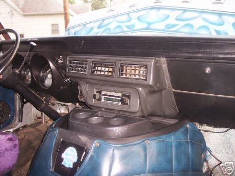 1978 Ford E250 - The interior of a 1978 Ford E250 van features custom blue upholstery and a flame-painted roof, suggesting a personalized build.