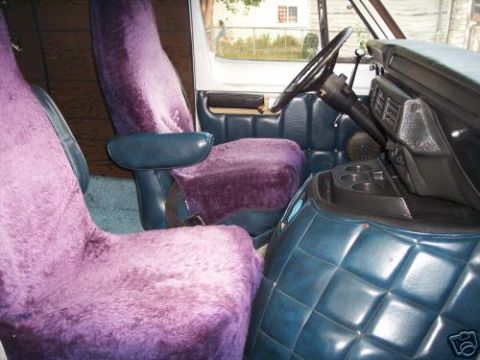 1978 Ford E250 - Van interior with purple fuzzy seat covers and blue quilted dashboard panels.