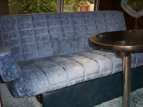 1978 Ford E250 - Interior view of a van's bench seat and table, showing custom upholstery.