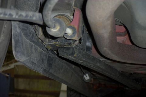 1997 Ford Taurus - Underbody shot of a welded-in black box-section subframe connector tied into the floor pan and rear frame rail, with fresh weld beads and s…